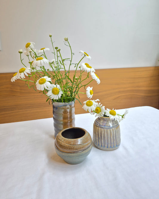 Decorative wall-mounted ceramic pots with flowers on a white background