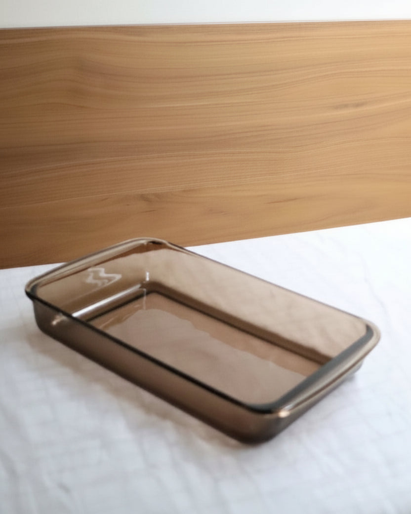 Rectangular glass baking dish on a white surface with a wooden background