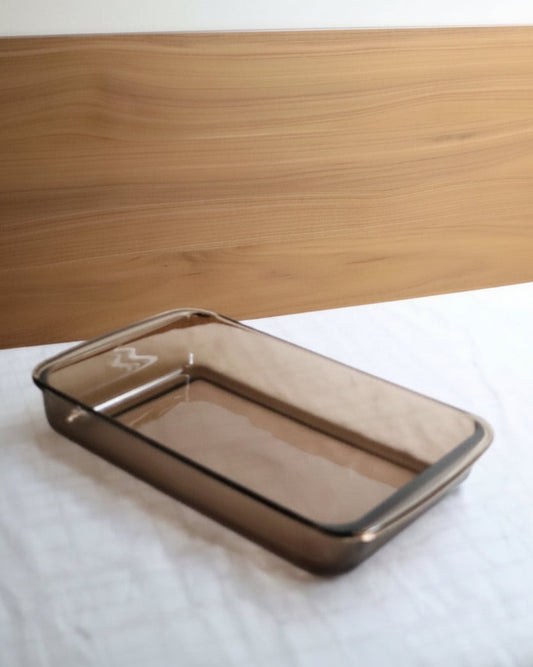 Rectangular glass baking dish on a white surface with a wooden background