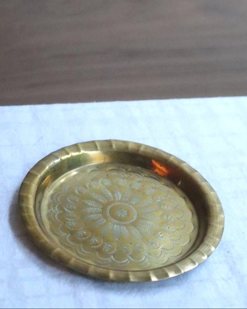 Brass tray with decorative patterns on a white surface